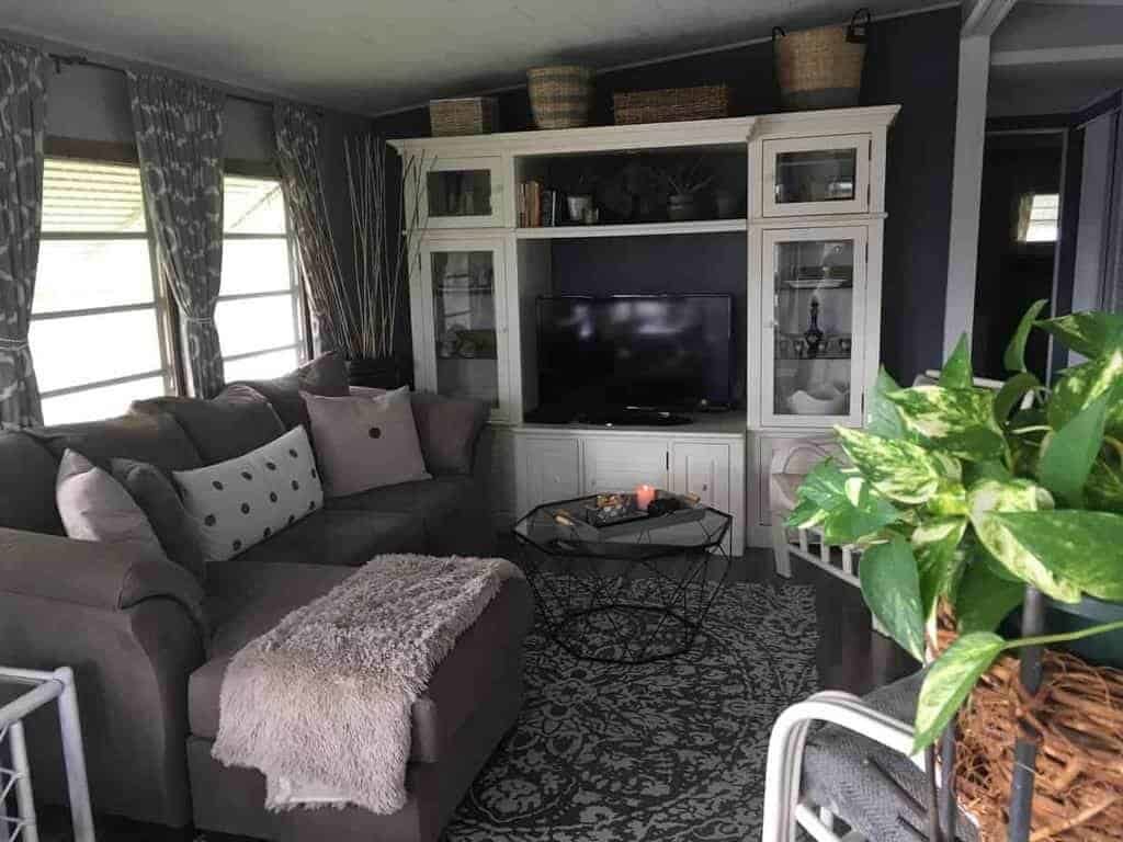Our Favorite Affordable Decorating Hacks For Mobile Homes 1964 chateau use curtains and dark paint to give small mobile home living room warmth and style