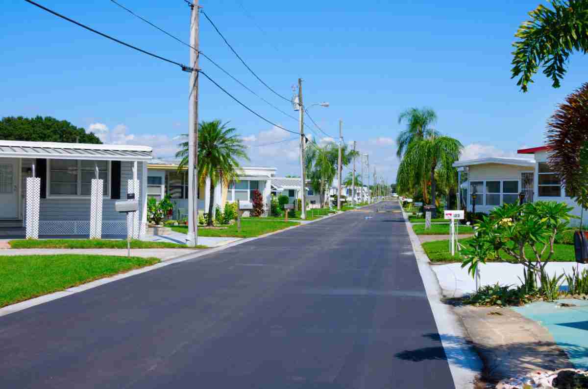 Street level view of a very well kept trailer park neighborhood in central Florida with nice yards and lush tropical vegetation.