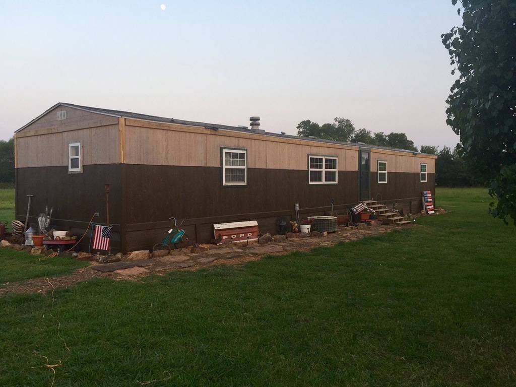 1985 Liberty single wide mobile home exterior after new siding and roofing
