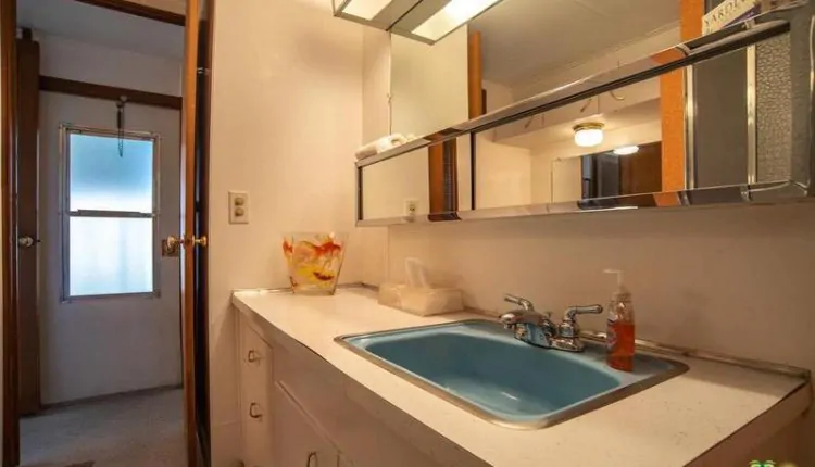 1962 Skyline is a Vintage Mobile Home Beauty - master bathroom with teal sink