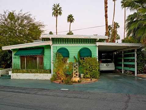Modern mobile home with desert landscaping and palm trees in Palm Springs.
